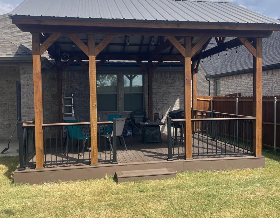 Covered patio with metal roof, cedar posts and metal railing on a composite deck