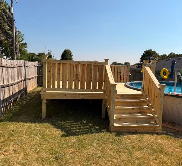 Pressure treated pool deck with privacy railing and wide stairs